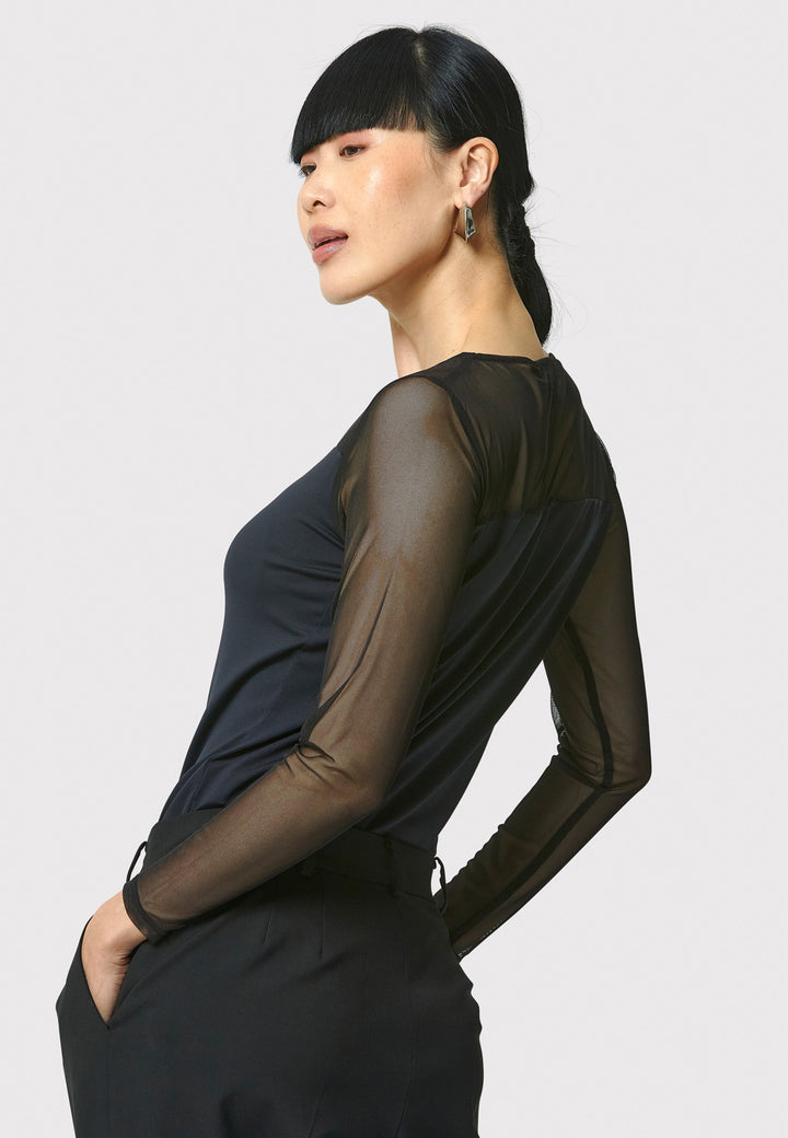 A signature hmca piece. our perennial best-seller back in black. This versatile top features a flattering mesh yoke and sleeves on a snug jersey body. Perfect underpinning to suiting or a more casual pant. Designed by Helen McAlinden in Ireland and made to last in Europe.