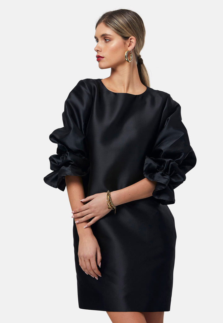 Step into the spotlight with Aurora, a chic short-shift dress in bold black. This stylish piece features a statement puff-ball sleeve, side seam pockets, and falls just above the knee. Crafted from a silk blend taffeta. Make a grand entrance with Aurora, perfect for a soiree or formal dressing.