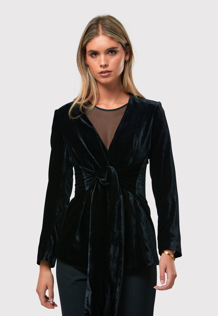 The Aurora Black Velvet Jacket is a stylish addition to your evening wardrobe. Designed with a wrap front and a self-tie attached belt for a customizable fit. Style with the Imogen black trousers for a full winter glam look, or pair with the coordinating Jill trousers for a chic and simple style.