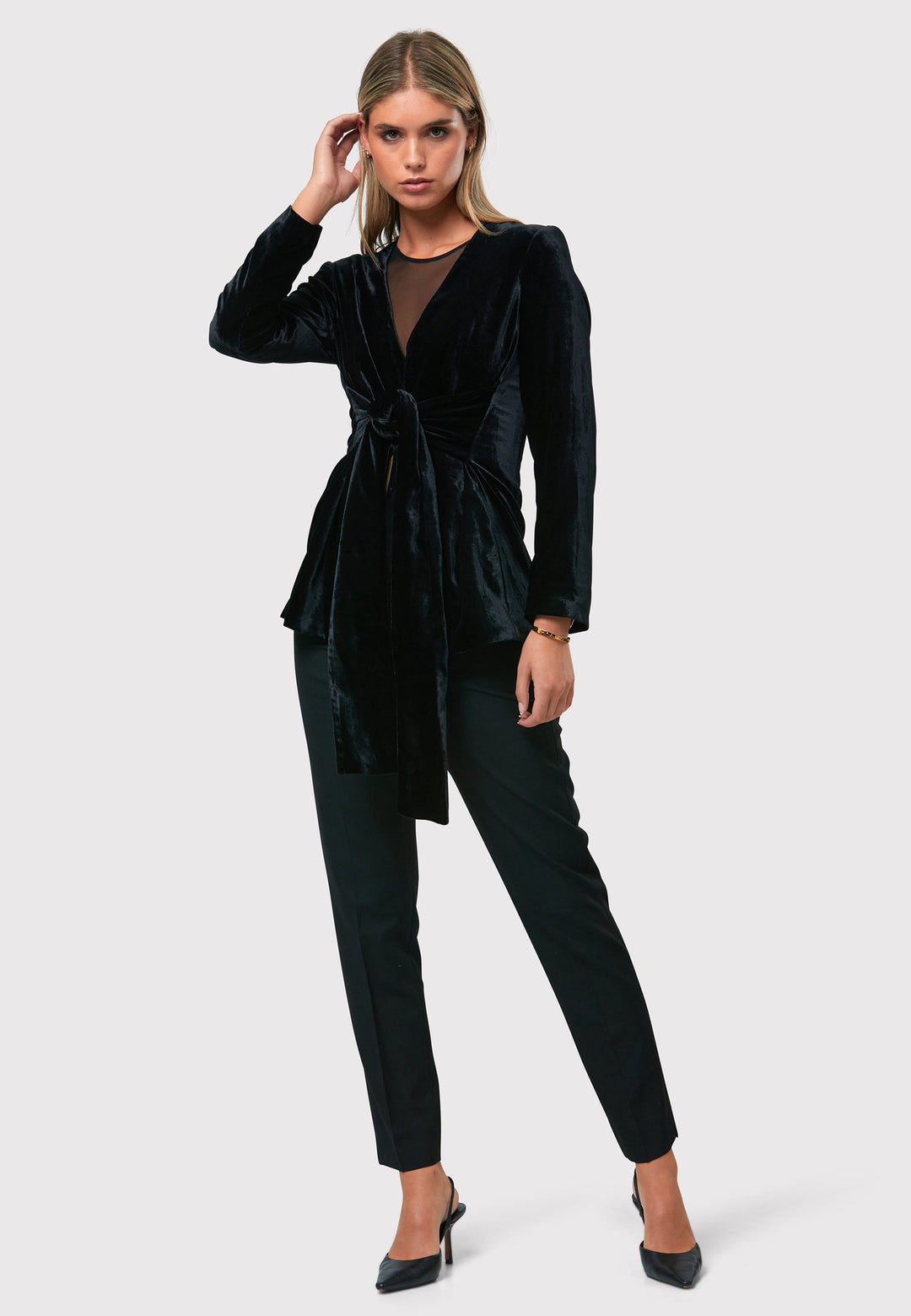 The Aurora Black Velvet Jacket is a stylish addition to your evening wardrobe. Designed with a wrap front and a self-tie attached belt for a customizable fit. Style with the Imogen black trousers for a full winter glam look, or pair with the coordinating Jill trousers for a chic and simple style.