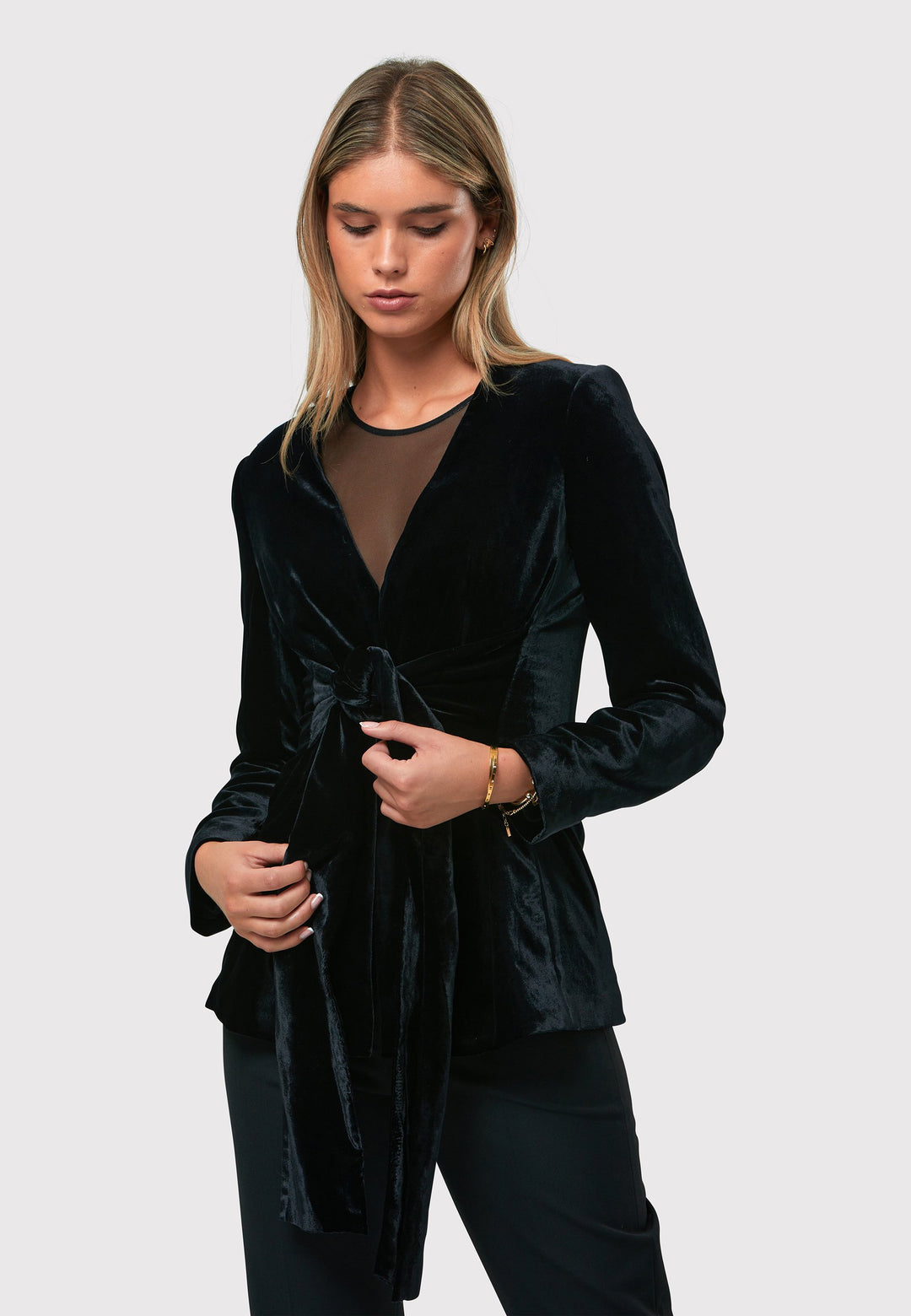 The Aurora Black Velvet Jacket is a stylish addition to your evening wardrobe. Designed with a wrap front and a self-tie attached belt for a customizable fit. Style with the Imogen black trousers for a full winter glam look, or pair with the coordinating Jill trousers for a chic and simple style.