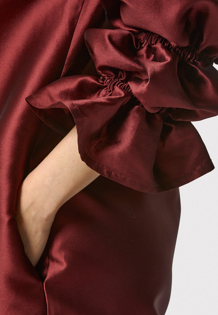 Step into the spotlight with Aurora, a chic short shift dress in a stunning mahogany red hue. This stylish piece features a statement puff-ball sleeve , side seam pockets, and falls above the knee. Crafted from a silk blend taffeta. Make a grand entrance with Aurora.