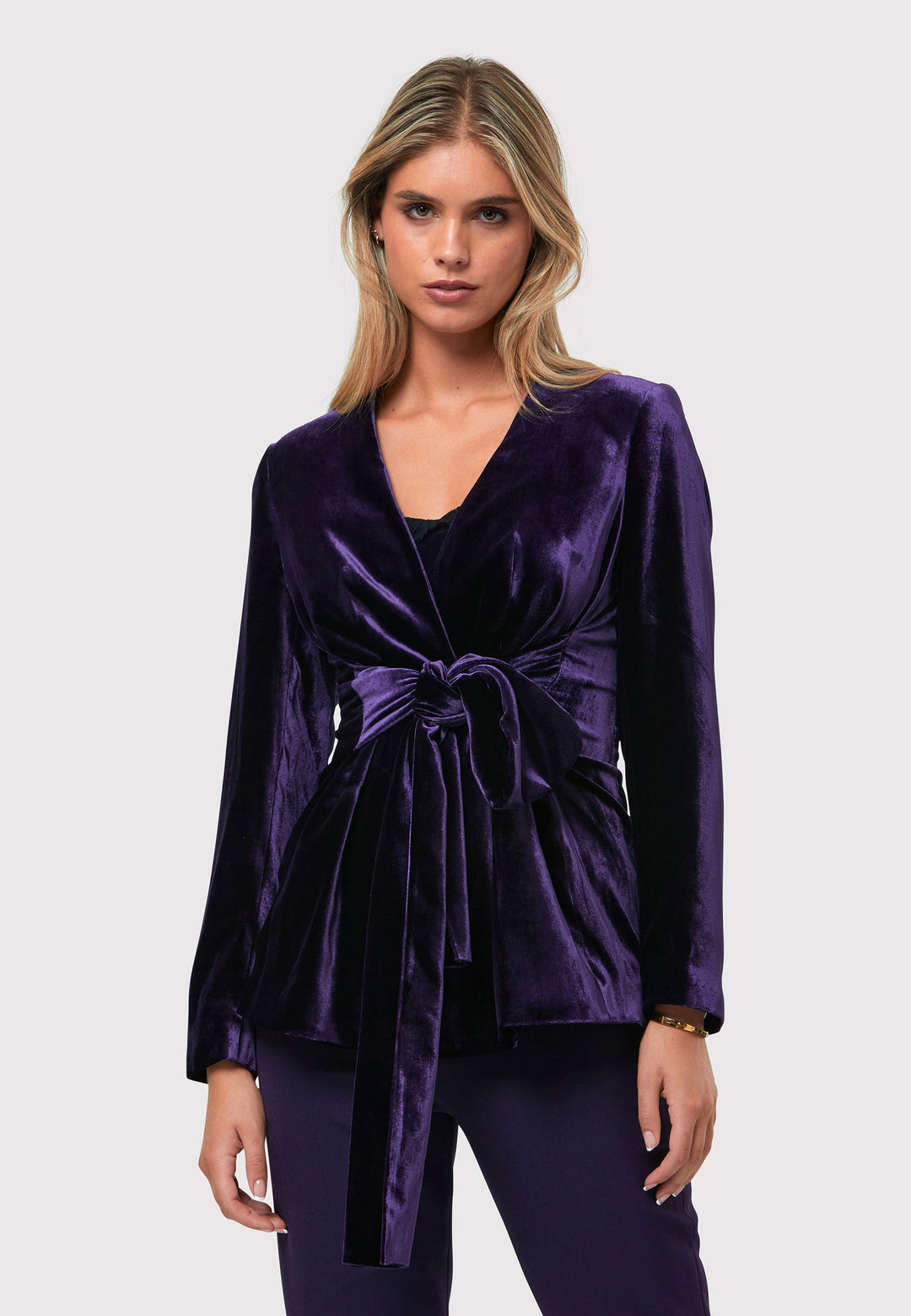 The Aurora Twilight Plum Velvet Jacket is an elegant addition to your evening wardrobe. Designed with a wrap front and a self-tie attached belt, allowing for a customizable fit. Pair with the matching Naomi trousers for a full glam look, or style it with the coordinating Jill trousers for a chic and simple style.