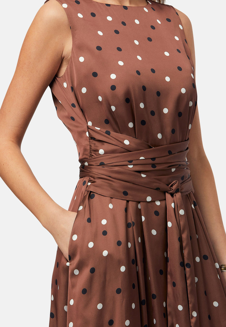 Have your very own Julia Roberts moment in our take of the iconic Pretty Woman polkadot dress. Avril is a sleeveless dress in a brown base, black and white polkadot print. The waist is accentuated with a gathered tied detail. Designed with a flattering empire line silhouette that gracefully skims the body, culminating in a chic mid-calf hemline. Perfect for date nights and semi-formal occasions.