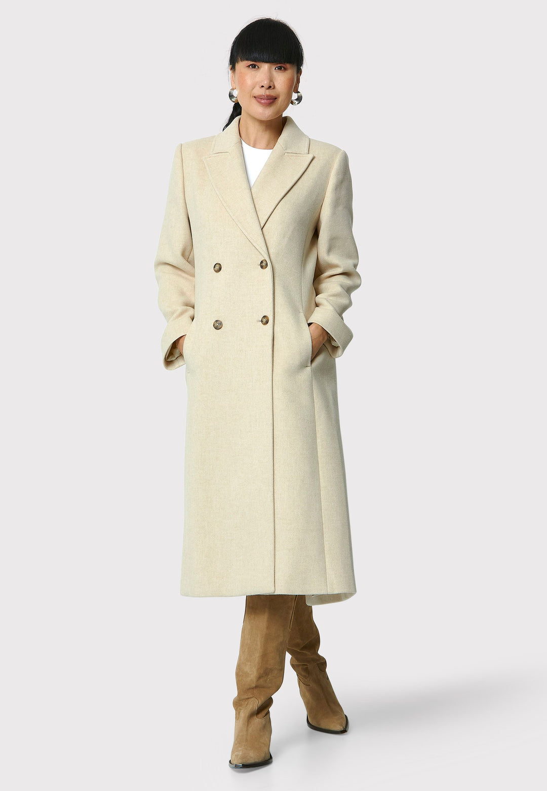 The Beryl winter white coat is crafted from a luxurious wool and cashmere blend melton. This fitted double-breasted coat features peak lapels, side seam pockets, and an overlapping back slit. Pair it with tailored trousers or a chic dress for a sophisticated winter look.