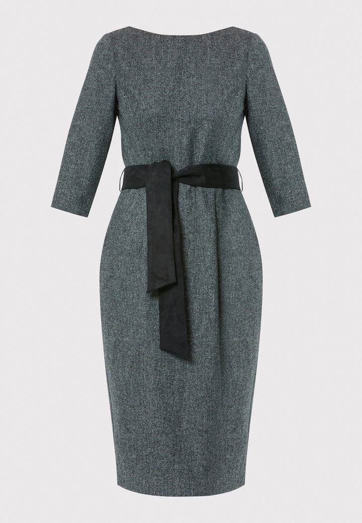 Caroline, a classic Helen McAlinden dress in charcoal grey. Crafted from a soft-touch wool blend, this bodycon dress features a bateau neckline, three-quarter sleeves and the front pleats allow the fabric to fall softly over the hip. The reversible belt with black suede on one side and self-fabric on the other for versatile styling. The dress is completed with side pockets and a back slit for added ease of movement.