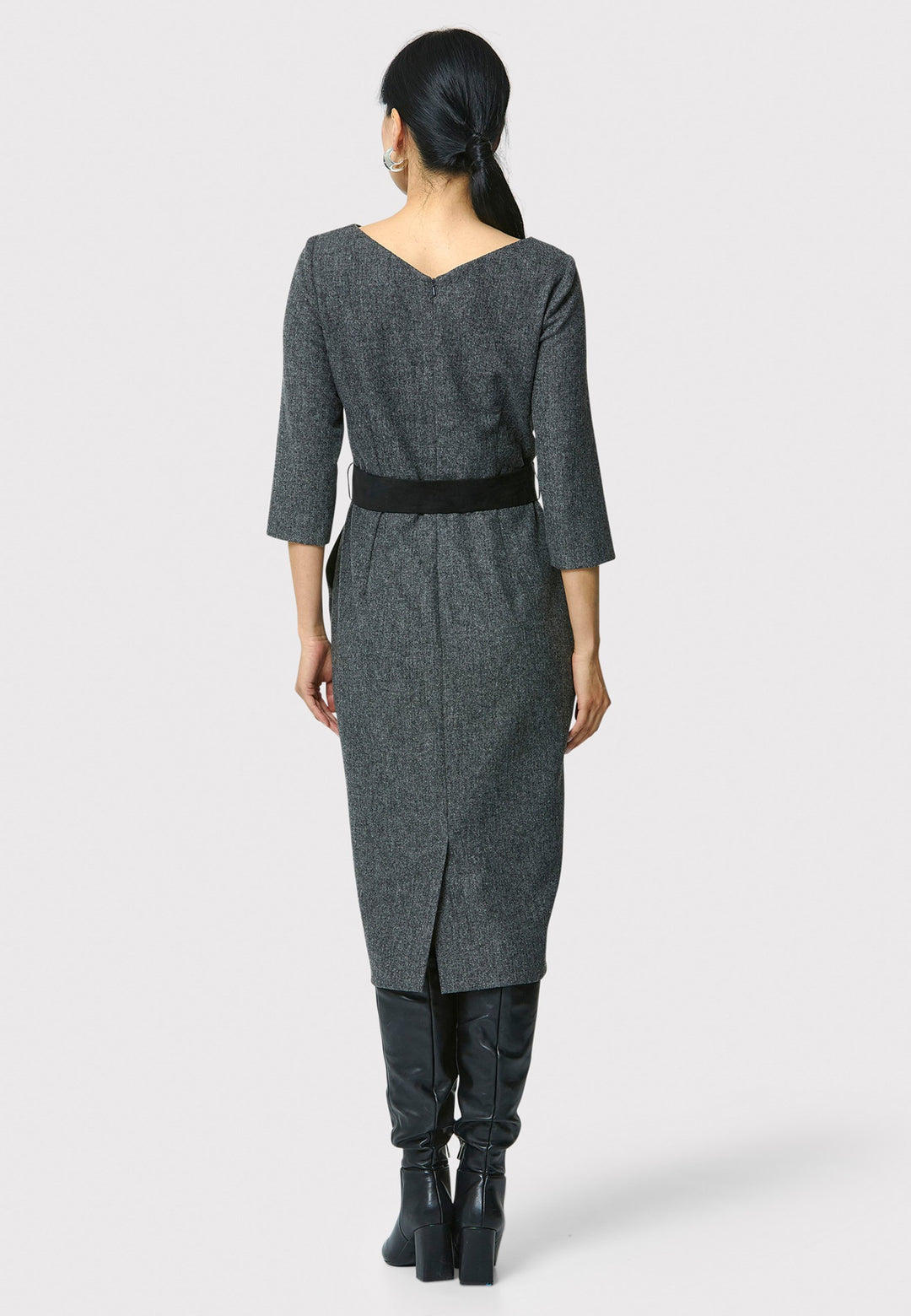 Caroline, a classic Helen McAlinden dress in charcoal grey. Crafted from a soft-touch wool blend, this bodycon dress features a bateau neckline, three-quarter sleeves and the front pleats allow the fabric to fall softly over the hip. The reversible belt with black suede on one side and self-fabric on the other for versatile styling. The dress is completed with side pockets and a back slit for added ease of movement.