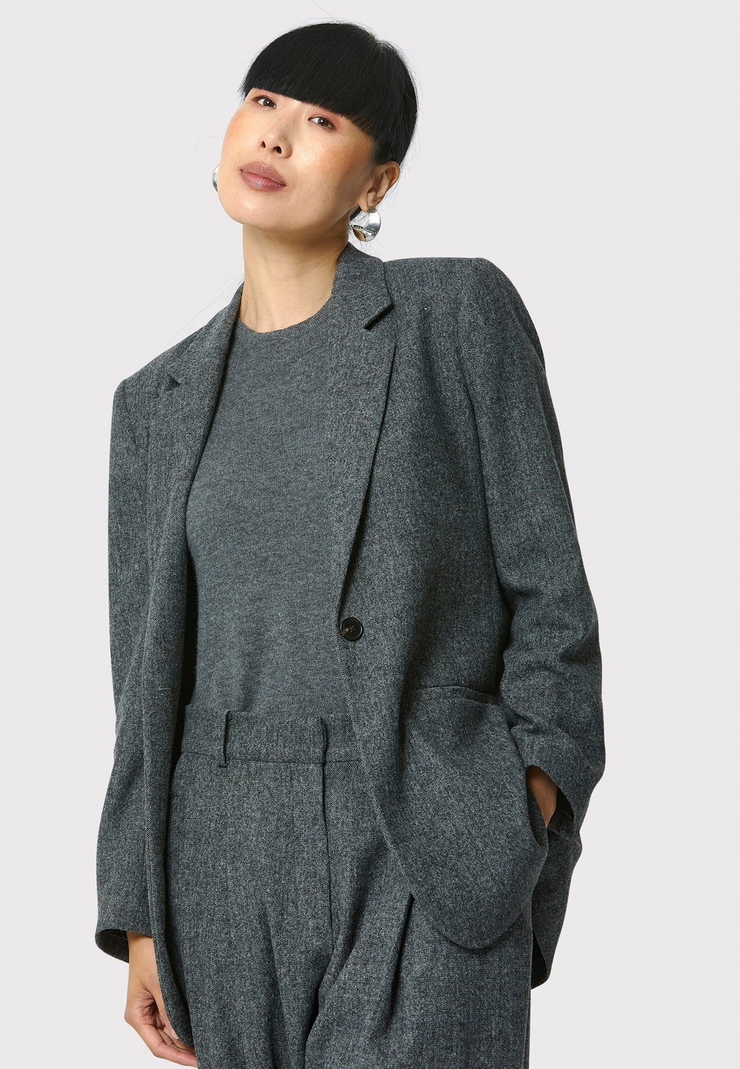 The Cassie boyfriend blazer in charcoal grey, crafted from a soft-touch wool blend, is an investment-worthy staple. Its minimalist design features a single button fastening, an oversized and slightly boxy silhouette, making it ideal for transeasonal outerwear. Complete a modern ensemble by pairing it with the coordinating Lyra pant.