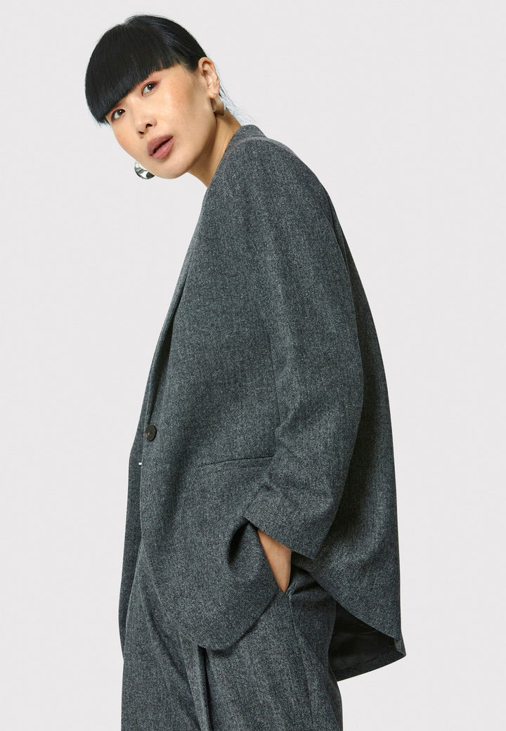 The Cassie boyfriend blazer in charcoal grey, crafted from a soft-touch wool blend, is an investment-worthy staple. Its minimalist design features a single button fastening, an oversized and slightly boxy silhouette, making it ideal for transeasonal outerwear. Complete a modern ensemble by pairing it with the coordinating Lyra pant.