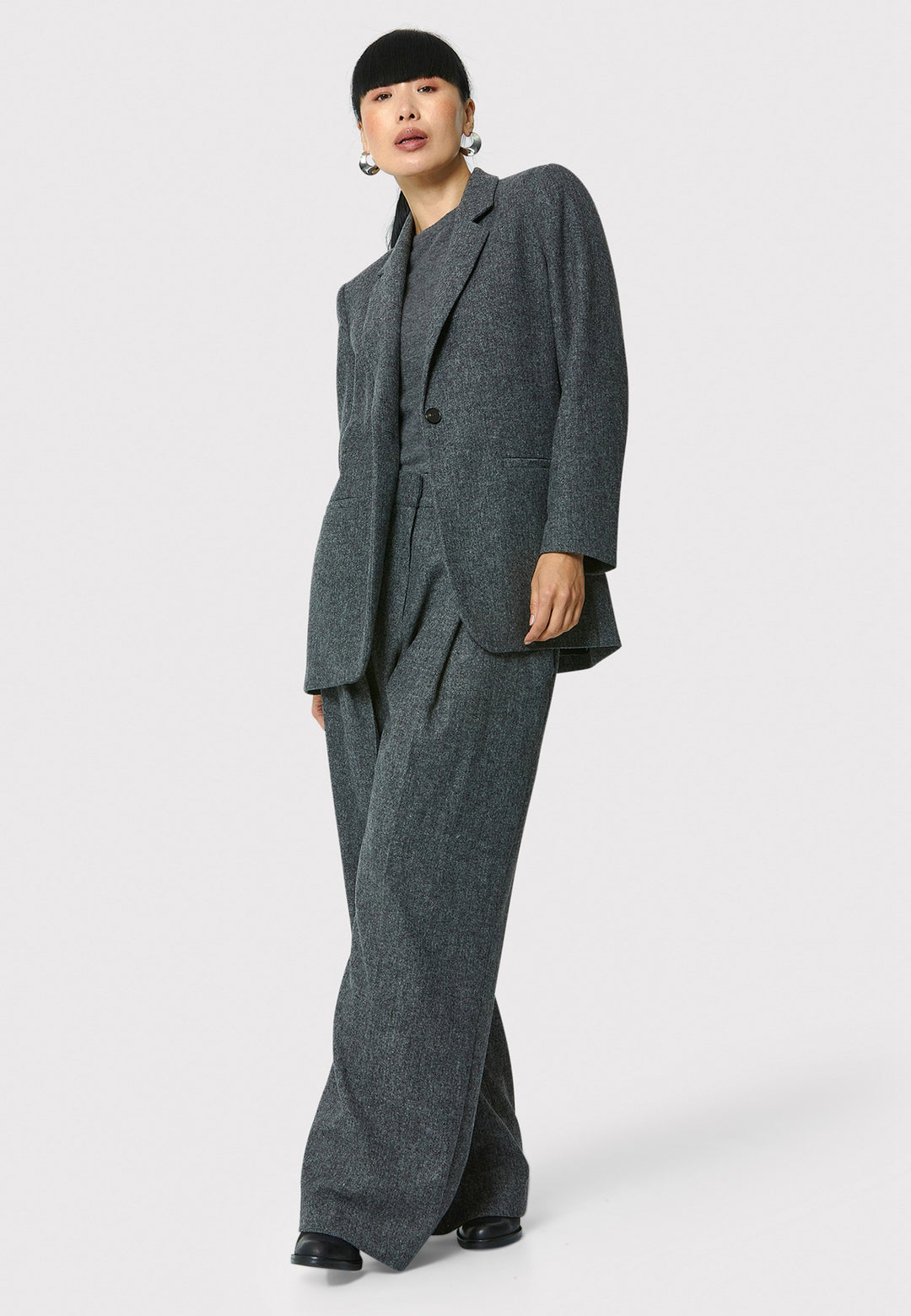 The Cassie boyfriend blazer in charcoal grey, crafted from a soft-touch wool blend, is an investment-worthy staple. Its minimalist design features a single button fastening, an oversized and slightly boxy silhouette, making it ideal for transeasonal outerwear. Complete a modern ensemble by pairing it with the coordinating Lyra pant.