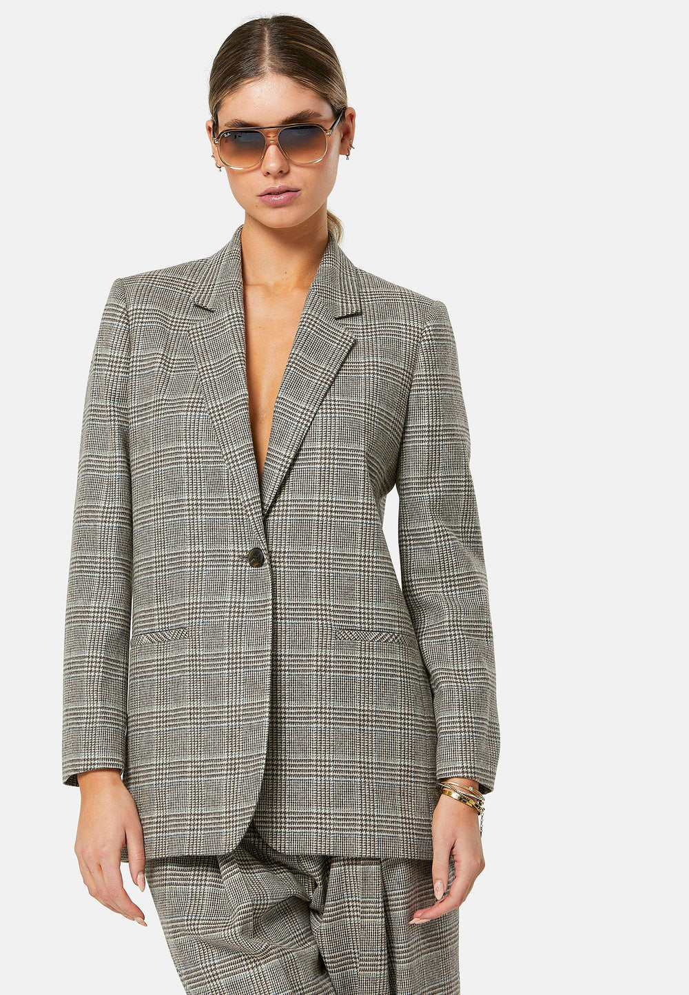 The Cassie Glen Check Jacket, a contemporary silhouette crafted in a soft-touch Magee lamsbwool. This boyfriend blazer boasts a minimalist design with a single button fastening and an oversized, slightly boxy silhouette. Pair the Marlena sleeveless cashmere top and matching Lyra Trousers, an effortless outfit.