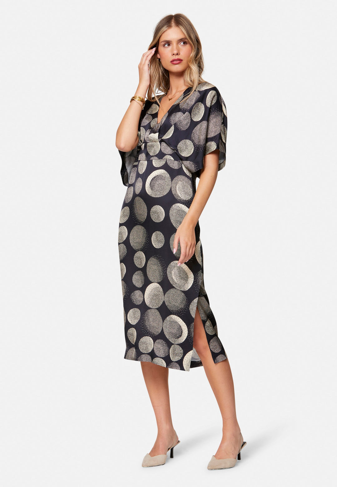 Eabha, the print dress with quiet drama. In fluid, silk-touch navy satin scattered with ivory lunar dots, it features a soft V-neckline, kimono sleeves and under-bust pleats that flatter the waistline. The column midi skirt is finished with discreet side seam pockets and a slit for ease, plus a neat keyhole back. Just add heels and minimal jewellery.
