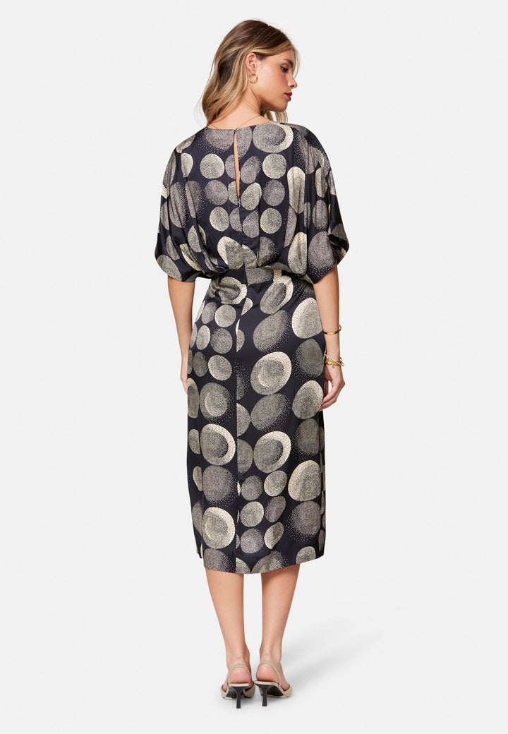 Eabha, the print dress with quiet drama. In fluid, silk-touch navy satin scattered with ivory lunar dots, it features a soft V-neckline, kimono sleeves and under-bust pleats that flatter the waistline. The column midi skirt is finished with discreet side seam pockets and a slit for ease, plus a neat keyhole back. Just add heels and minimal jewellery.