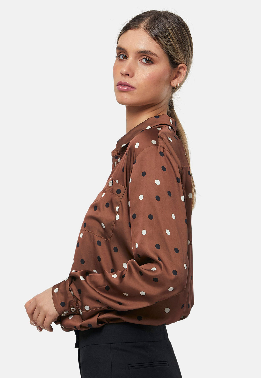 Elevate your day edit with the Ella Brown Polkadot shirt. Featuring patch pockets and a back center box pleat. Tuck into the black Jill trousers, add heels and a blazer, to create a refined daytime look that easily transitions into evening plans.