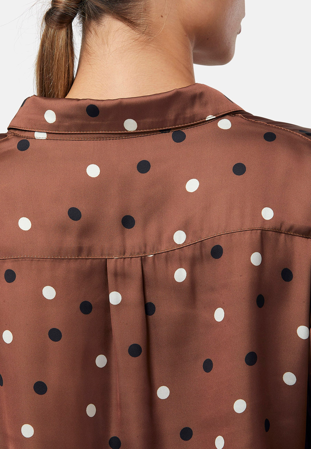 Elevate your day edit with the Ella Brown Polkadot shirt. Featuring patch pockets and a back center box pleat. Tuck into the black Jill trousers, add heels and a blazer, to create a refined daytime look that easily transitions into evening plans.