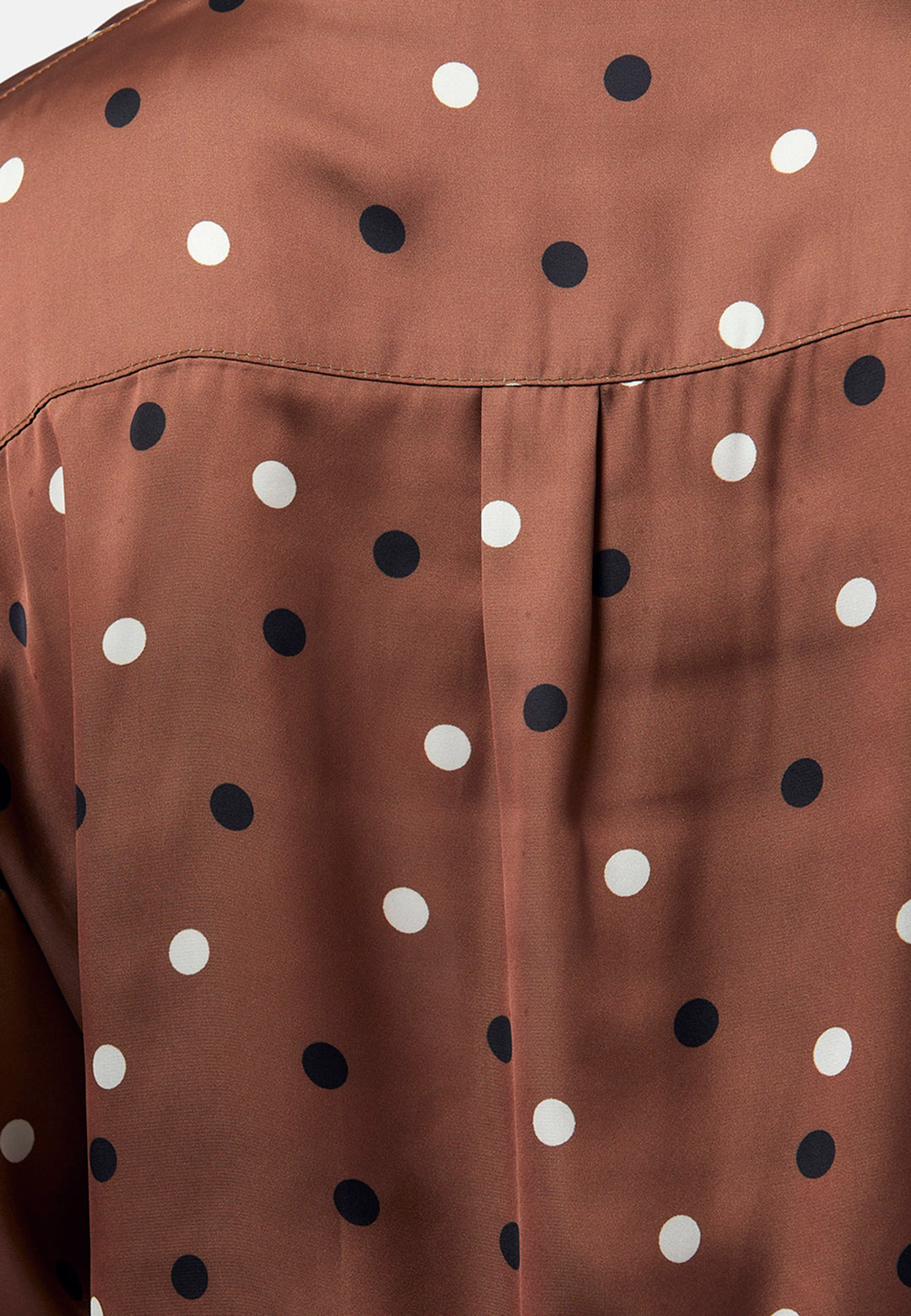 Elevate your day edit with the Ella Brown Polkadot shirt. Featuring patch pockets and a back center box pleat. Tuck into the black Jill trousers, add heels and a blazer, to create a refined daytime look that easily transitions into evening plans.