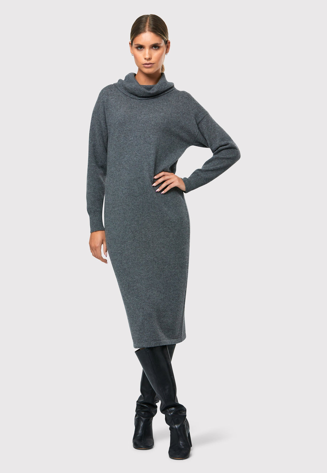 Have you met the Elora Charcoal Grey Cashmere Dress? A chic and versatile addition to your wardrobe. This midi-length dress features a loose, drapey polo neck, exuding effortless elegance. With full-length sleeves and tight ribbed cuffs, it offers a stylish yet comfortable fit. Crafted from luxurious cashmere, this dress effortlessly combines sophistication and comfort, making it the perfect go-to piece for any occasion.