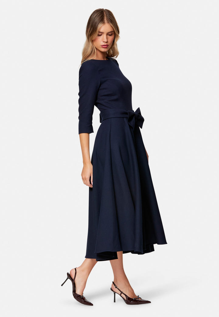 Eva, the modern fit-and-flare. Inspired by Hollywood glamour, this silhouette features a fitted bodice, flared skirt and a flattering scoop back. Designed with a round neckline, side seam pockets and a centre-back zip. The detachable bow belt adds a versatile finishing touch.