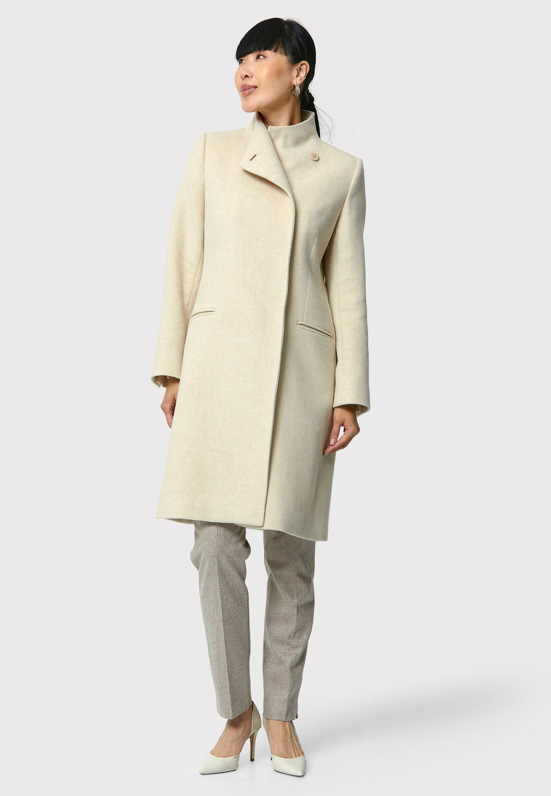 The Faye Winter White Coat, crafted from a luxurious wool blend melton, is perfect for your workwear wardrobe. This coat features a high collar, a sleek silhouette, and discreet pockets for added functionality. Its versatile design makes it suitable for both professional and casual occasions. Pair it with our Magee suiting or Taupe suiting for a polished and sophisticated look.