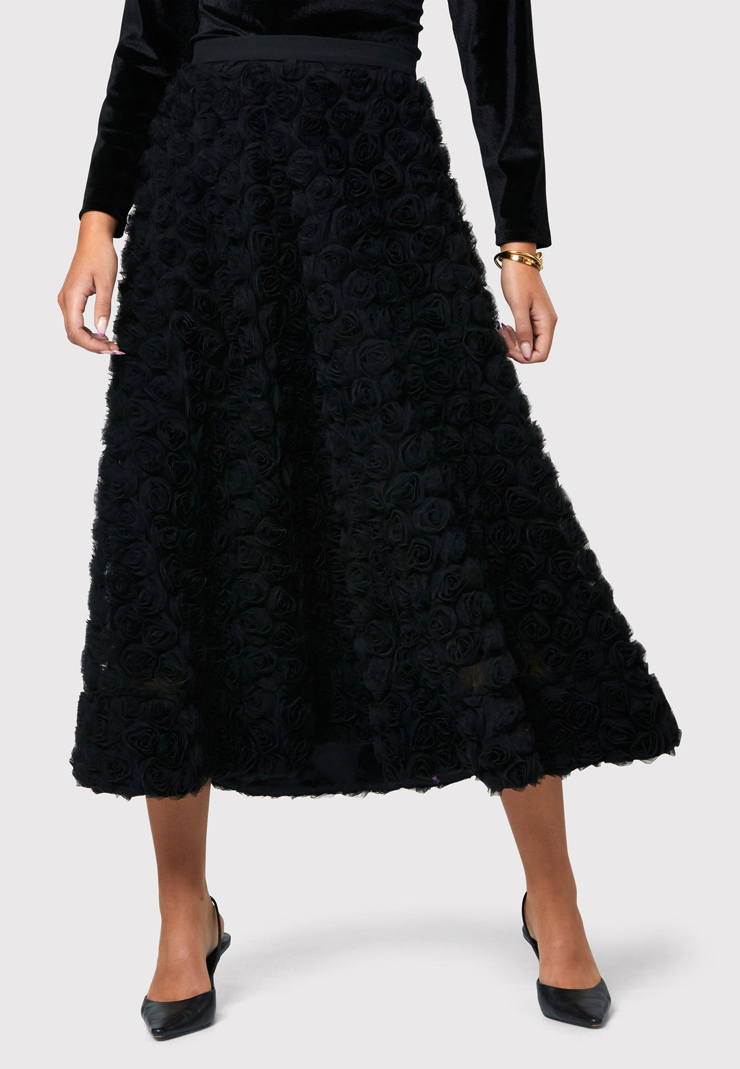 Make a statement with the Black Felicity Skirt. An ankle grazing full skirt crafted in an sculptural rose detailed fabric. Pair it with a fitted timeless black top for a chic look, perfect for any special occasion.