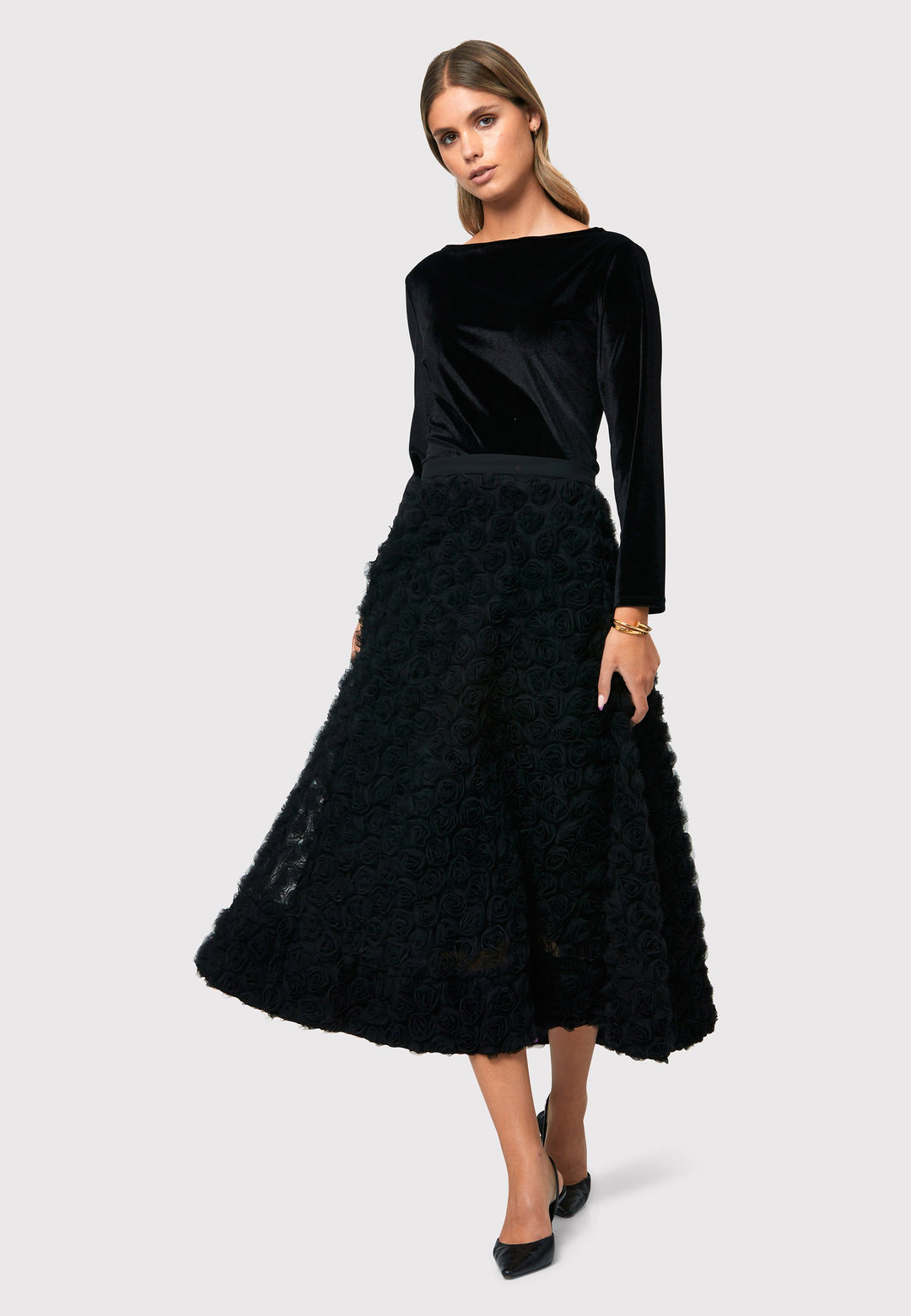 Make a statement with the Black Felicity Skirt. An ankle grazing full skirt crafted in an sculptural rose detailed fabric. Pair it with a fitted timeless black top for a chic look, perfect for any special occasion.