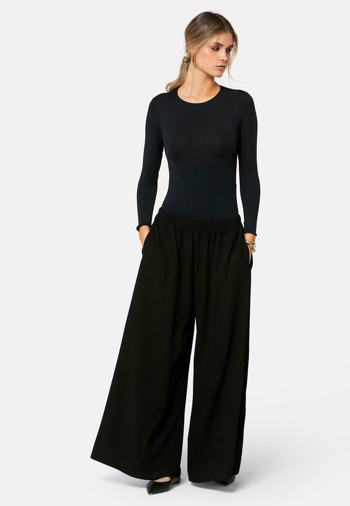 Imogen, black culottes in a fluid satin back crepe. Feature a flowy wide-leg, elasticated waistband and side pockets. A relaxed yet dressy look. Coordinate with black sparkly tops and matching Lydiah trench for a complete outfit.