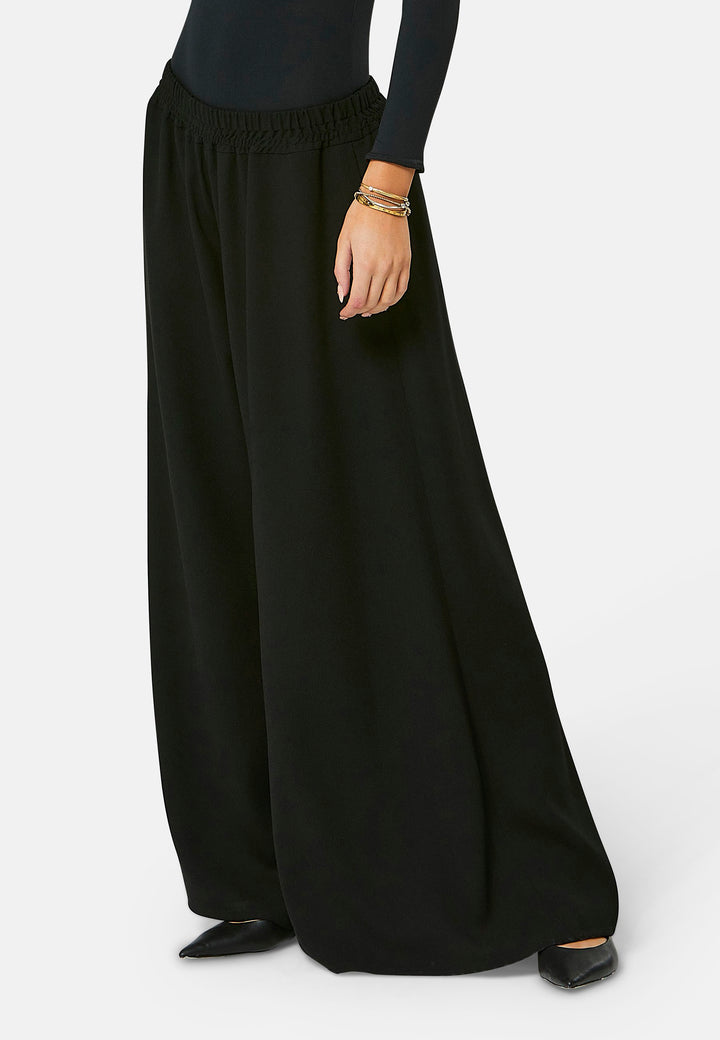 Imogen, black culottes in a fluid satin back crepe. Feature a flowy wide-leg, elasticated waistband and side pockets. A relaxed yet dressy look. Coordinate with black sparkly tops and matching Lydiah trench for a complete outfit.