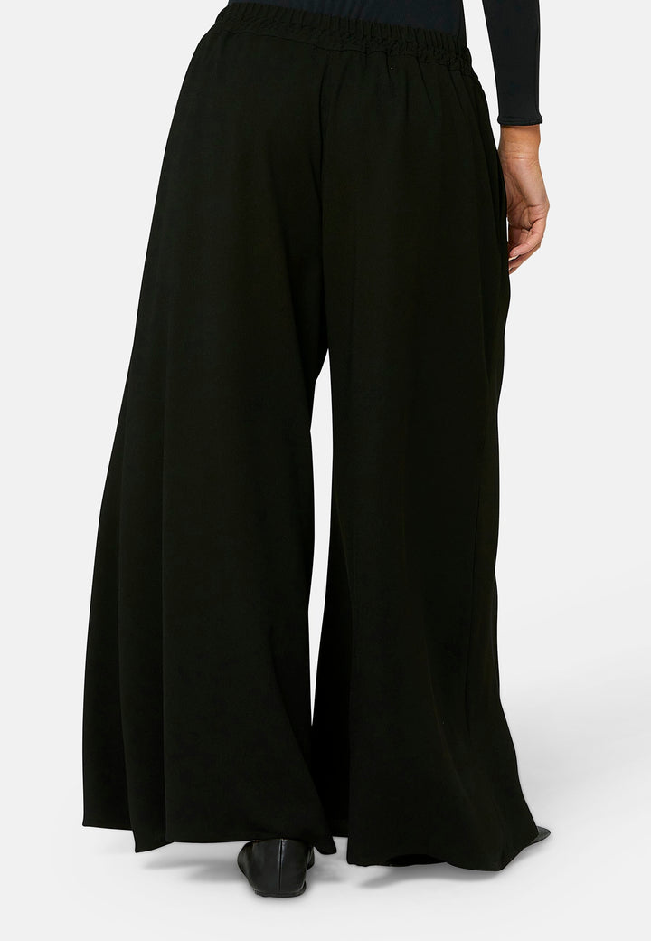 Imogen, black culottes in a fluid satin back crepe. Feature a flowy wide-leg, elasticated waistband and side pockets. A relaxed yet dressy look. Coordinate with black sparkly tops and matching Lydiah trench for a complete outfit.