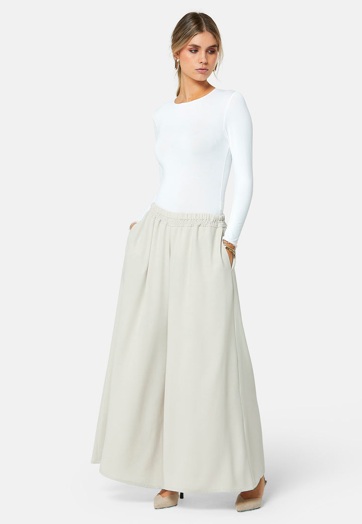 Imogen, Stone culottes in a fluid satin back crepe. Feature a flowy wide-leg, elasticated waistband and side pockets. A relaxed yet dressy look. Coordinate with white timeless tops and matching Lydiah trench for a complete outfit.