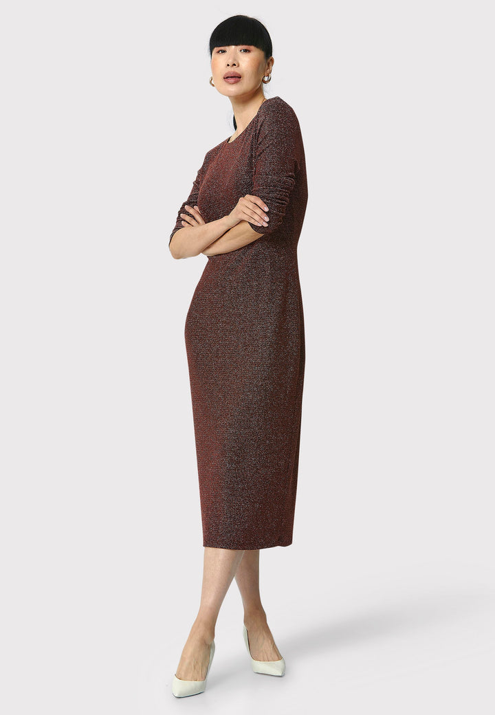 Introducing the Jamie Copper Shimmer Dress, an elegant bodycon piece with full-length sleeves. Made from sparkly black jersey fabric, it features a slash neck with a slight V-back for added allure. Its midi length perfectly balances classic and modern styles. Ideal for any occasion, this dress adds a touch of glamour to your look.