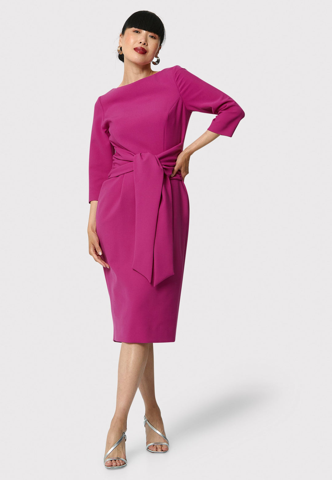 Transition effortlessly from desk to dinner in the Karen Raspberry Dress. This flattering silhouette features an attached belt that gathers at the side seams, defining the waist beautifully. The pencil skirt falls to a chic mid-calf length, complemented by a sophisticated slash neck. Side seam pockets add comfort and style. Crafted from signature tricotine with a hint of stretch. This dress takes you anywhere.