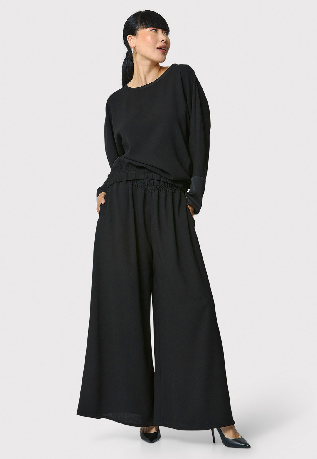 Lal, black top in fluid satin back crepe. A relaxed fit, elastic waistband, Dropped Shoulder sleeves, and satin cuffs. Wear with the coordinating Deliliah or Imogen Pant.