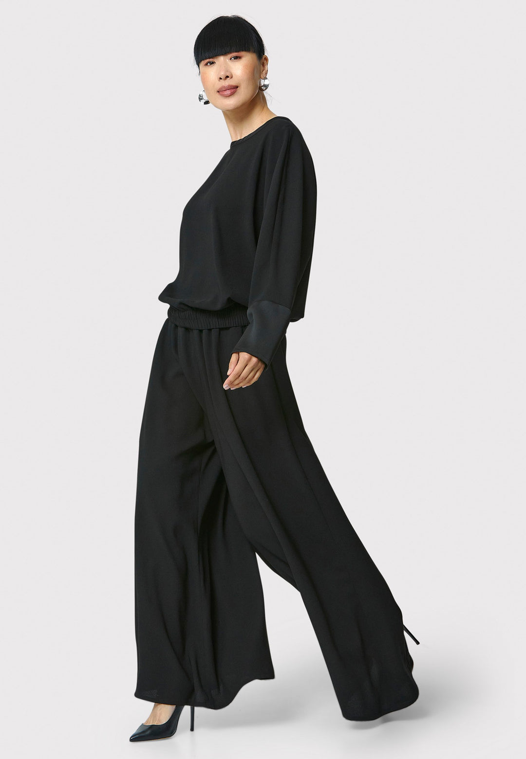 Lal, black top in fluid satin back crepe. A relaxed fit, elastic waistband, Dropped Shoulder sleeves, and satin cuffs. Wear with the coordinating Deliliah or Imogen Pant.