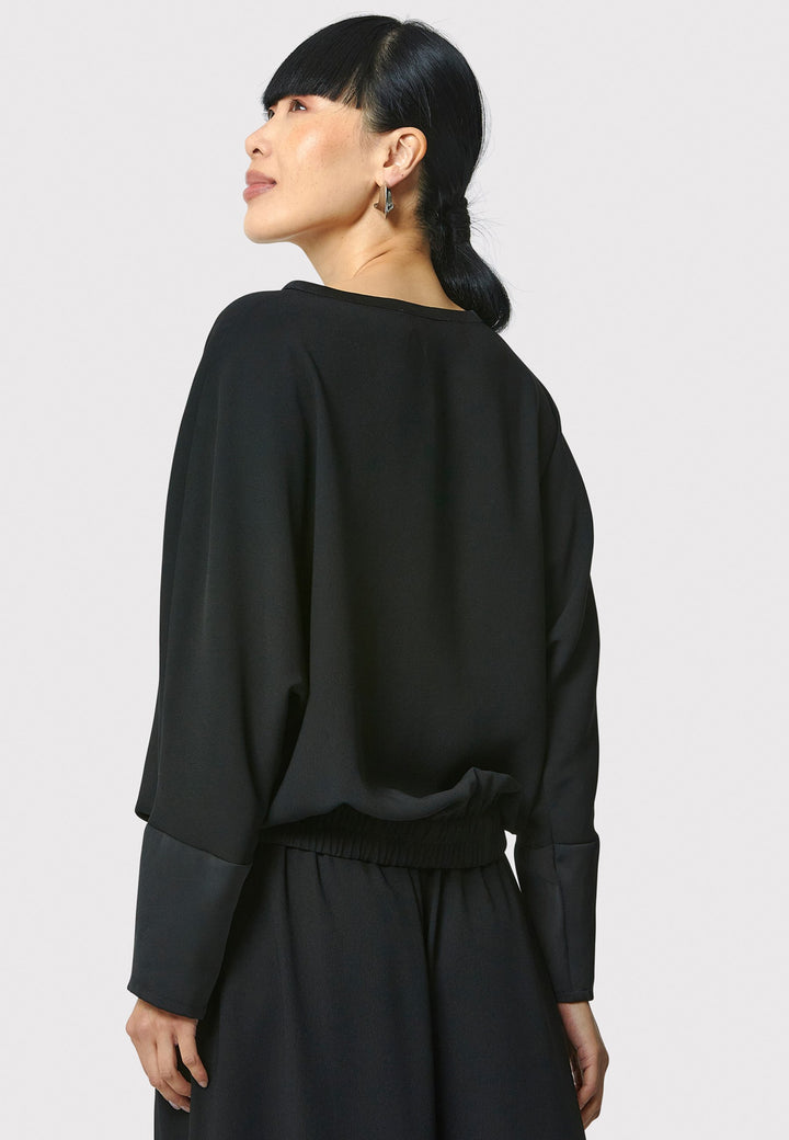 Lal, black top in fluid satin back crepe. A relaxed fit, elastic waistband, Dropped Shoulder sleeves, and satin cuffs. Wear with the coordinating Deliliah or Imogen Pant.