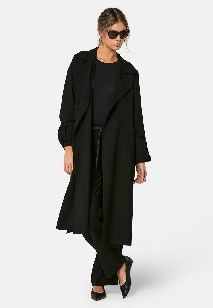 Lydiah, black trench coat in a fluid satin back crepe. This coat features a relaxed, flowing silhouette, a self-tie belt, and front pockets. The design includes buttoned cuffs and a wide lapel. Pair with coordinating trouser for a chic monochromatic look.