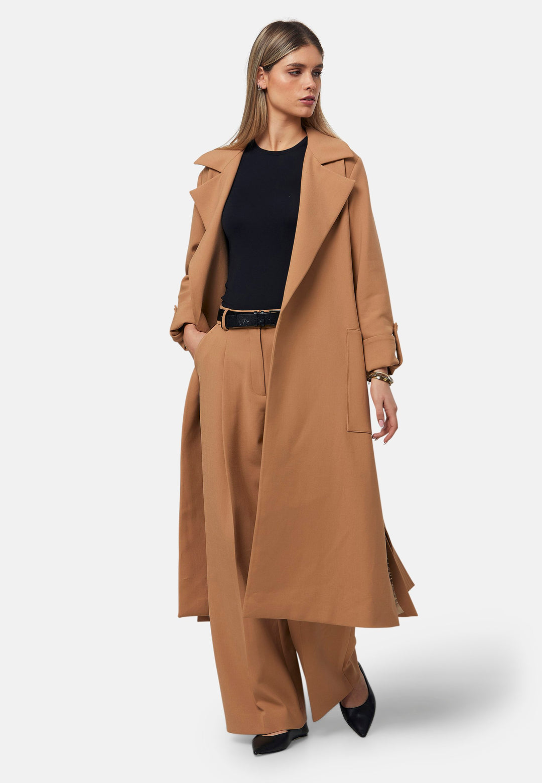 The Lydiah Coat is a minimalist trench style in camel. This coat features a relaxed, straight silhouette with a detachable self-tie belt, and front patch pockets. The design includes buttoned turn back cuffs and a wide lapel. Pair with our coordinating Lyra trouser for a chic monochromatic look.