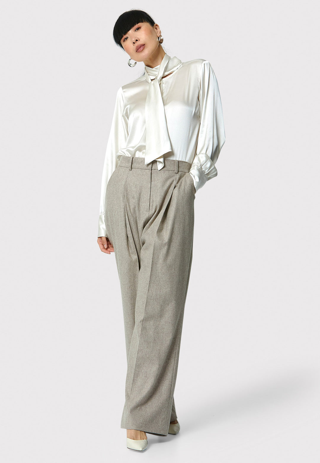 Lyra Trousers in melange mink, crafted from a soft-touch wool blend. This pleated front wide-leg relaxed fit trousers offer a timeless and versatile look suitable for both professional and casual settings. Pair the Anastasia Ivory silk blouse and matching Marlow Jacket for a chic tonal outfit.