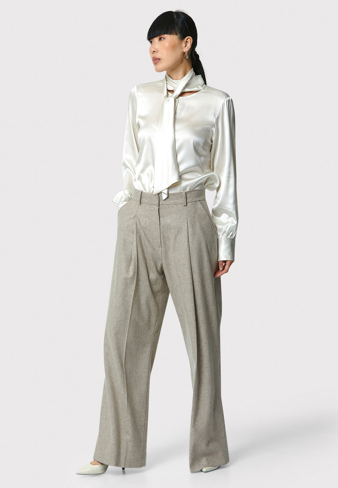 Lyra Trousers in melange mink, crafted from a soft-touch wool blend. This pleated front wide-leg relaxed fit trousers offer a timeless and versatile look suitable for both professional and casual settings. Pair the Anastasia Ivory silk blouse and matching Marlow Jacket for a chic tonal outfit.