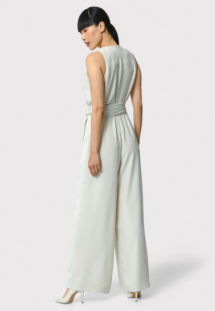 Marie-Claire, a sleeveless stone jumpsuit in fluid satin back crepe. Featuring a wide-leg silhouette and satin stripes on the side seams. It comes with a detachable self-fabric belt that can be used to cinch the waist or worn around the neck. Includes practical side pockets for added convenience. Perfect for relaxed yet sophisticated evening dressing.