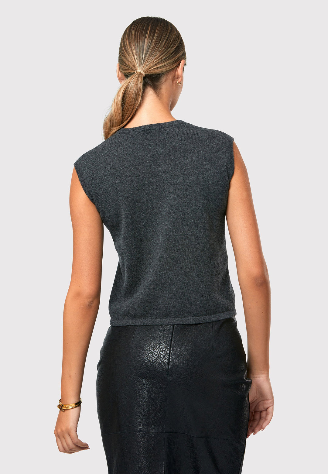 The Marlena Charcoal Grey Cashmere Sweater-Vest is a sleeveless round-neck top that offers versatile styling options. Wear it as a simple underpinning for the matching ballet wrap to complete a coordinated look. Alternatively, layer it as a sweater vest over your favorite crisp white shirts for a stylish and contemporary outfit. Made from luxurious cashmere, the Marlena Sweater-Vest adds an extra layer of comfort and sophistication to your wardrobe.