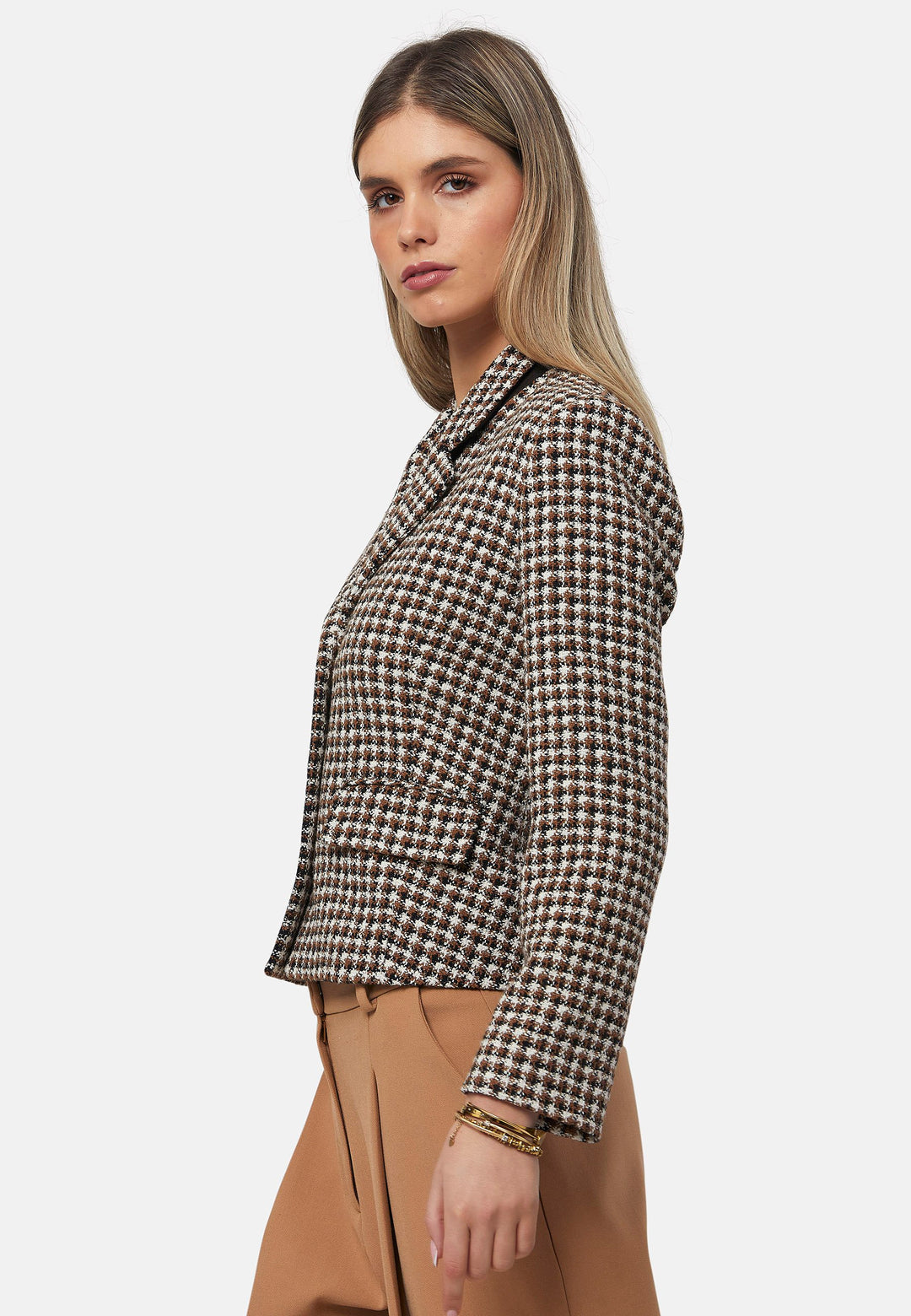 This bouclé tailored blazer features a classic houndstooth pattern in earthy brown, black, and white tones. Designed with a structured fit, it includes a notched lapel, three-button front closure, and flap pockets for a timeless look. Perfect for elevating both office and casual outfits.