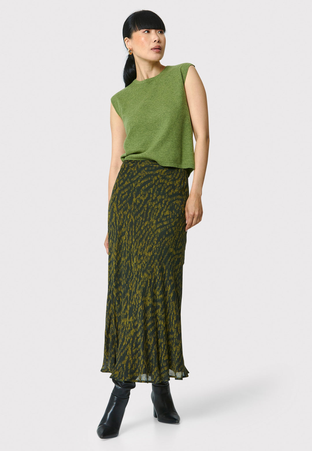 Add a touch of elegance to your wardrobe with the bias-cut dark green forest print skirt. Crafted from a luxurious blend of viscose and silk, it features a fluid silhouette that drapes beautifully. The unique pattern and midi length make it a versatile piece, perfect for both day and night. Pair with our black timeless tops and boots for a chic, modern look or make a statement by pairing with the Marlena Chartreuse green sleeveless cashmere top.