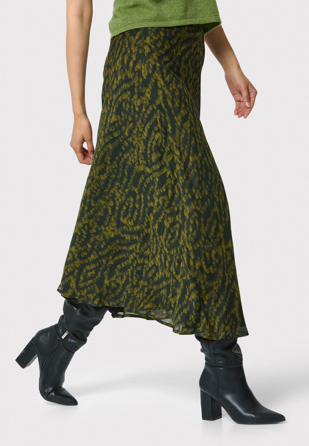 Add a touch of elegance to your wardrobe with the bias-cut dark green forest print skirt. Crafted from a luxurious blend of viscose and silk, it features a fluid silhouette that drapes beautifully. The unique pattern and midi length make it a versatile piece, perfect for both day and night. Pair with our black timeless tops and boots for a chic, modern look or make a statement by pairing with the Marlena Chartreuse green sleeveless cashmere top.