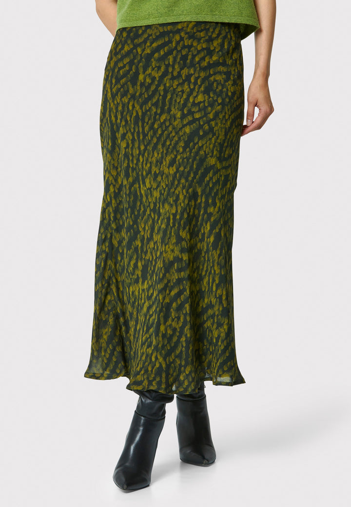 Add a touch of elegance to your wardrobe with the bias-cut dark green forest print skirt. Crafted from a luxurious blend of viscose and silk, it features a fluid silhouette that drapes beautifully. The unique pattern and midi length make it a versatile piece, perfect for both day and night. Pair with our black timeless tops and boots for a chic, modern look or make a statement by pairing with the Marlena Chartreuse green sleeveless cashmere top.