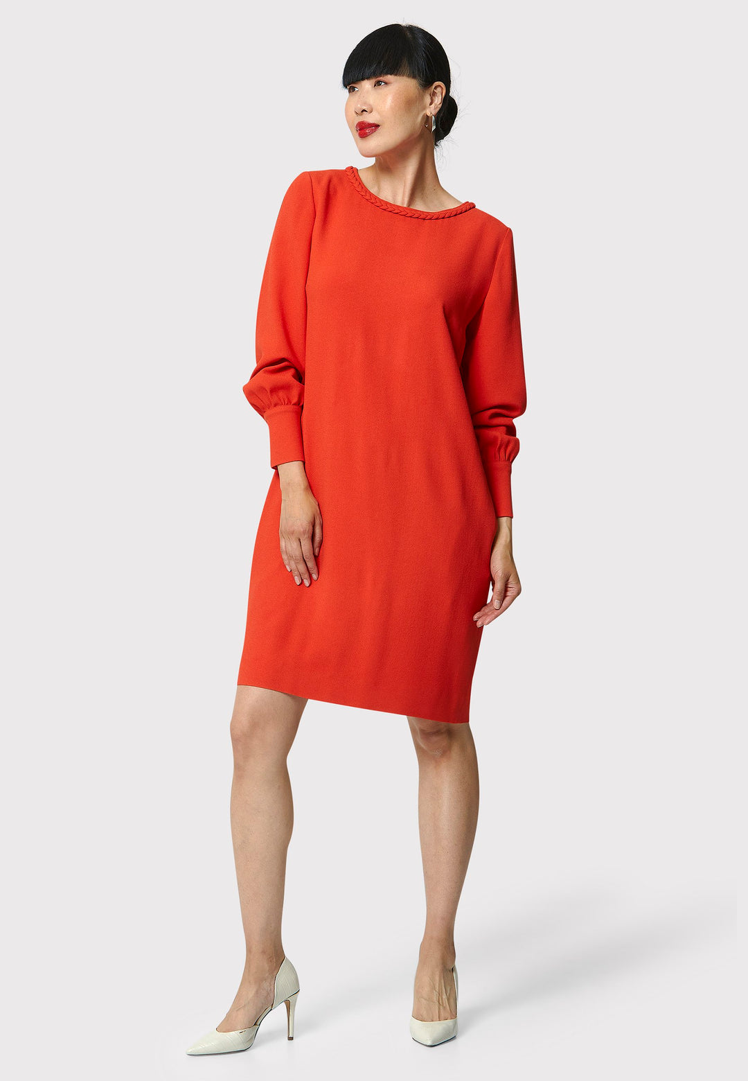 The Rachel Shift Dress is crafted in a vibrant burnt orange acetate and viscose blend crepe. This modern shift dress features a round neckline trimmed with an elegant plait trim. The relaxed-fit sleeves gather softly into buttoned cuffs, adding a refined touch. With convenient side pockets and a knee-length skirt, this dress is both stylish and practical. Perfect for work, wine or dining.