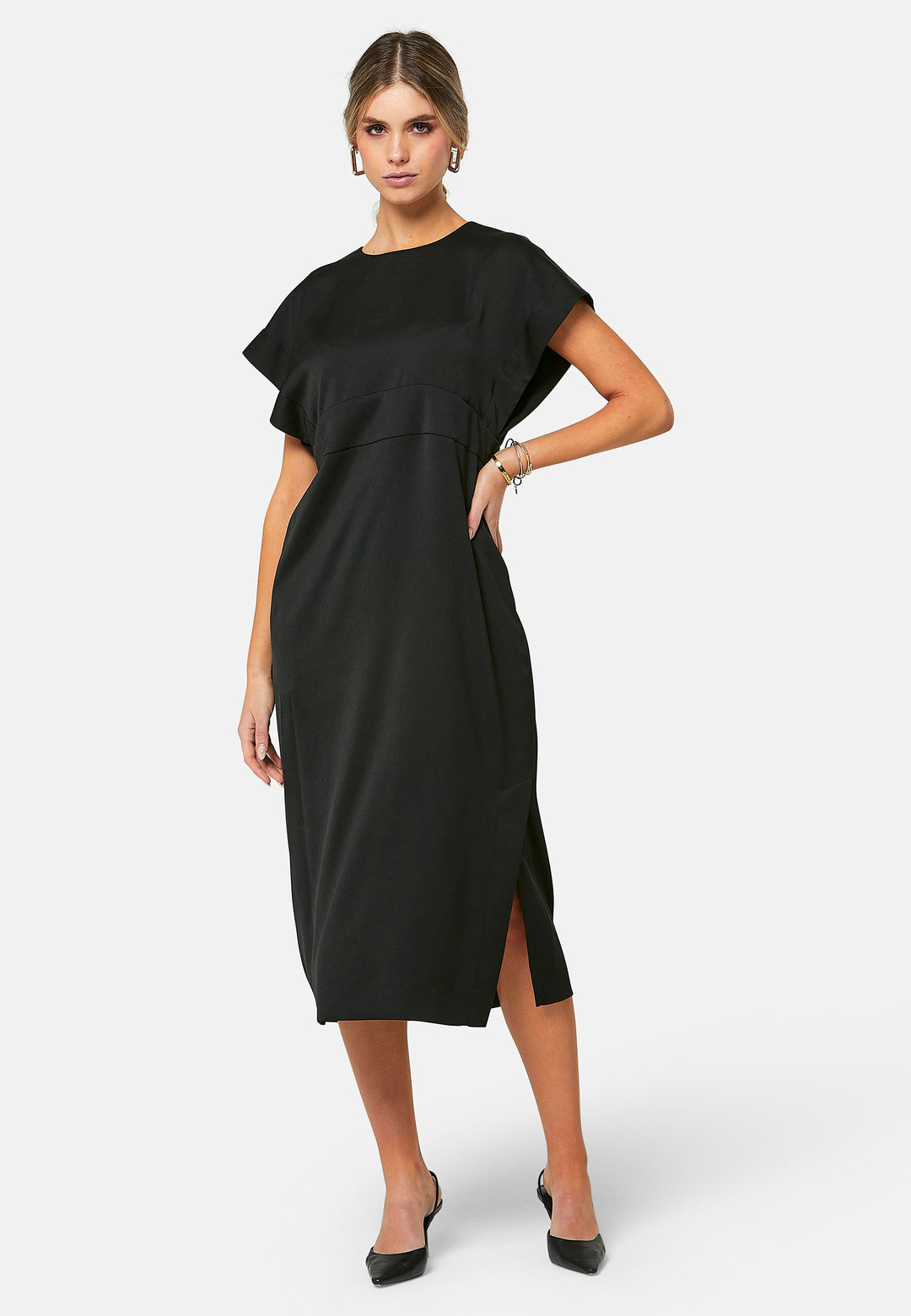 Elevate your wardrobe with Shiv, a simple black midi dress in a fluid satin back crepe. Featuring dropped sleeves, a gathered back waist seam, and a side slit for ease of movement. The back has a keyhole detail with a button closure.