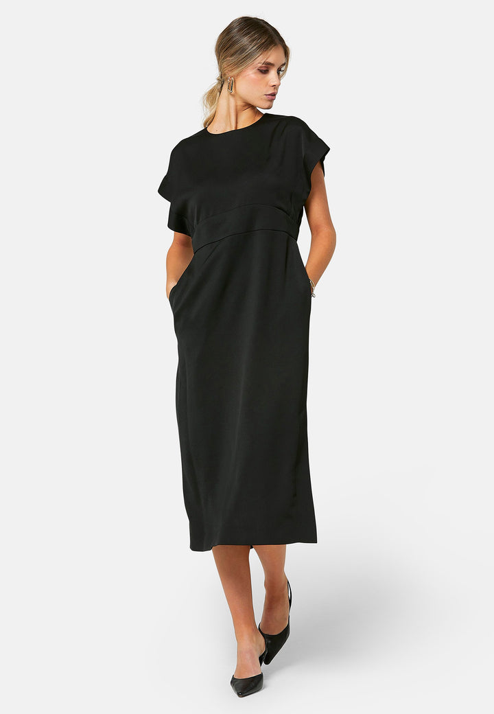 Elevate your wardrobe with Shiv, a simple black midi dress in a fluid satin back crepe. Featuring dropped sleeves, a gathered back waist seam, and a side slit for ease of movement. The back has a keyhole detail with a button closure.