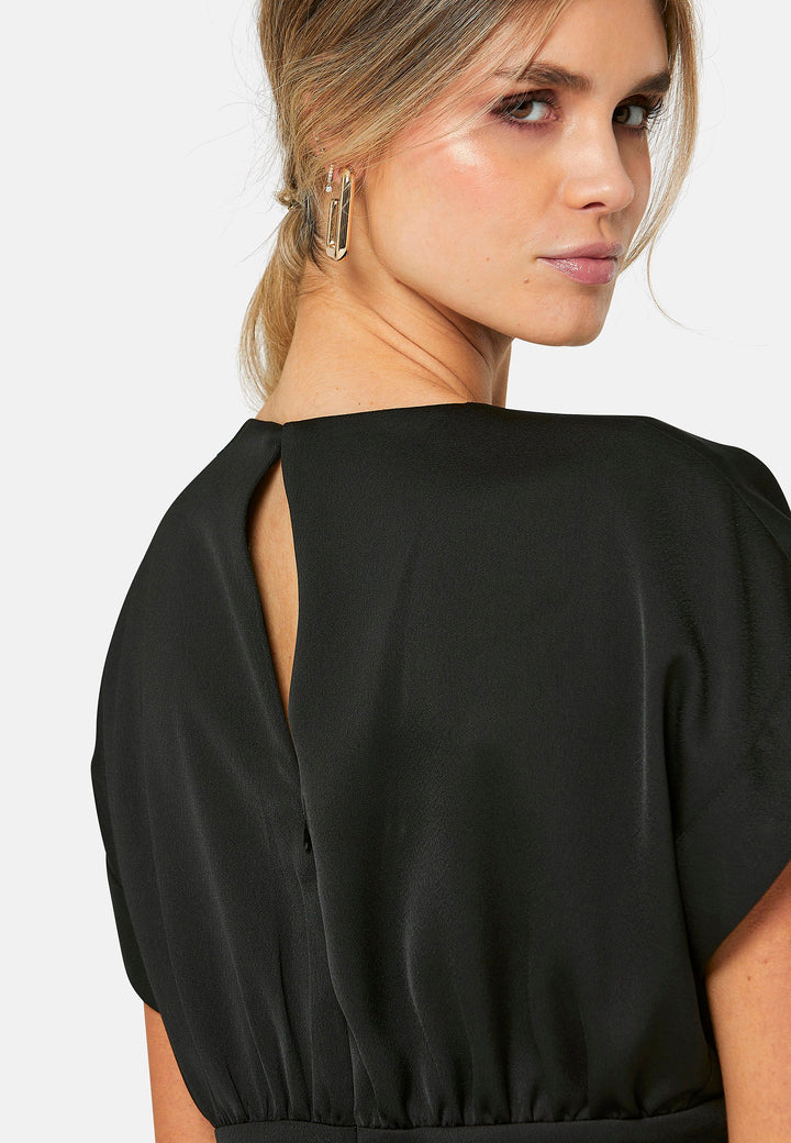 Elevate your wardrobe with Shiv, a simple black midi dress in a fluid satin back crepe. Featuring dropped sleeves, a gathered back waist seam, and a side slit for ease of movement. The back has a keyhole detail with a button closure.