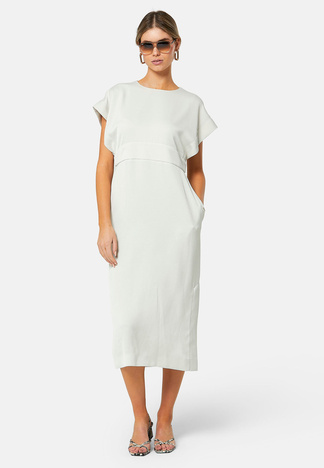 Elevate your wardrobe with Shiv, a simple stone midi dress in a fluid satin back crepe. Featuring dropped sleeves, a gathered back waist seam, and a side slit for ease of movement. The back has a keyhole detail with a button closure.