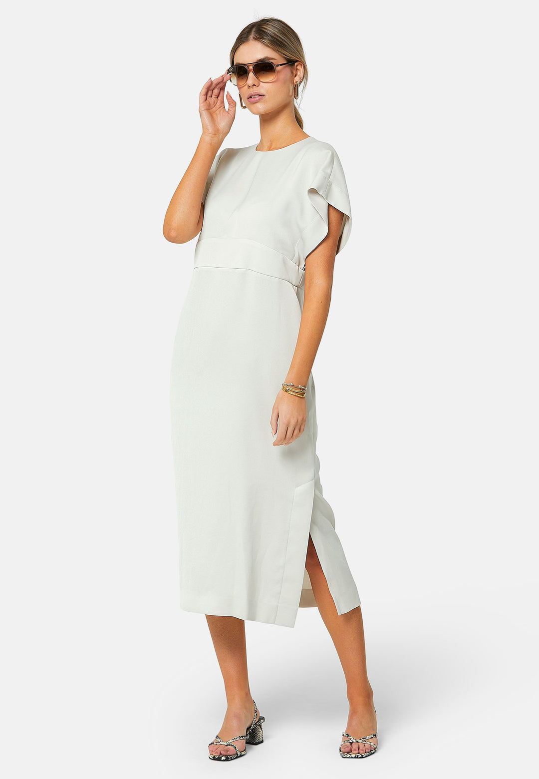 Elevate your wardrobe with Shiv, a simple stone midi dress in a fluid satin back crepe. Featuring dropped sleeves, a gathered back waist seam, and a side slit for ease of movement. The back has a keyhole detail with a button closure.